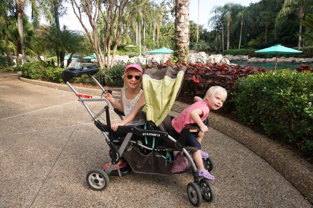 two girls in double stroller sitting back to back in seaworld