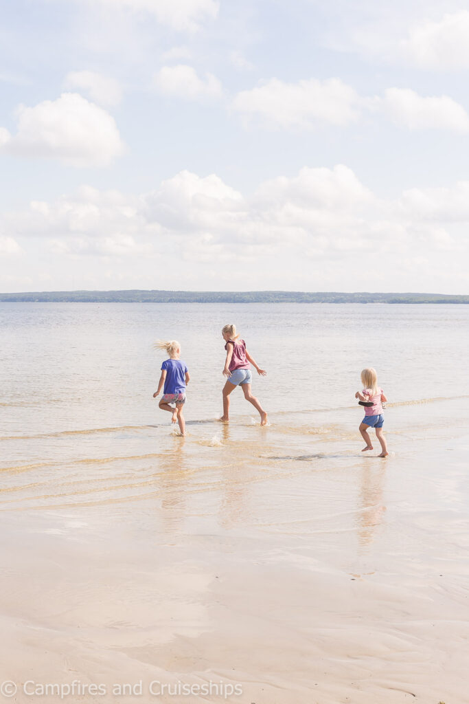 three girls running on grand beach manitoba west beach