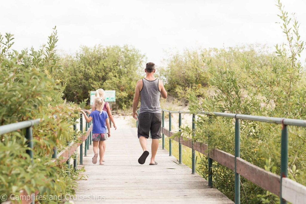 foot bridge at grand beach provincial park three girls and dad