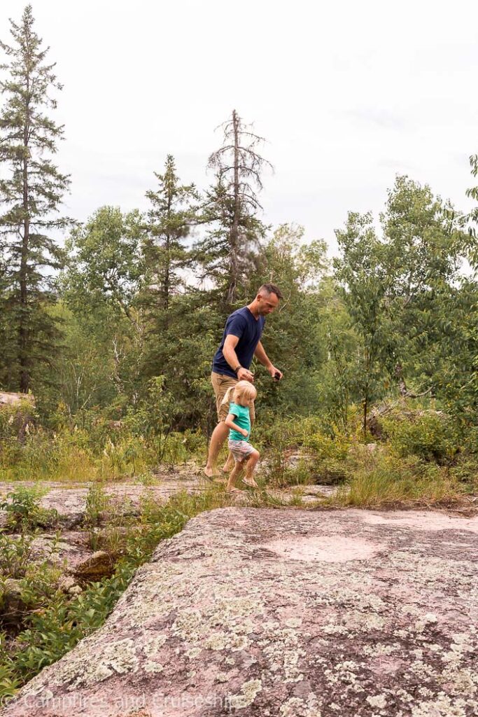 father and daughter walking on the rocks in whiteshell provincial park