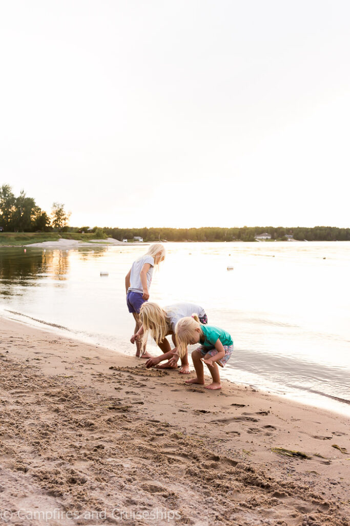 nutimik lake beach with three girls digging in the sand